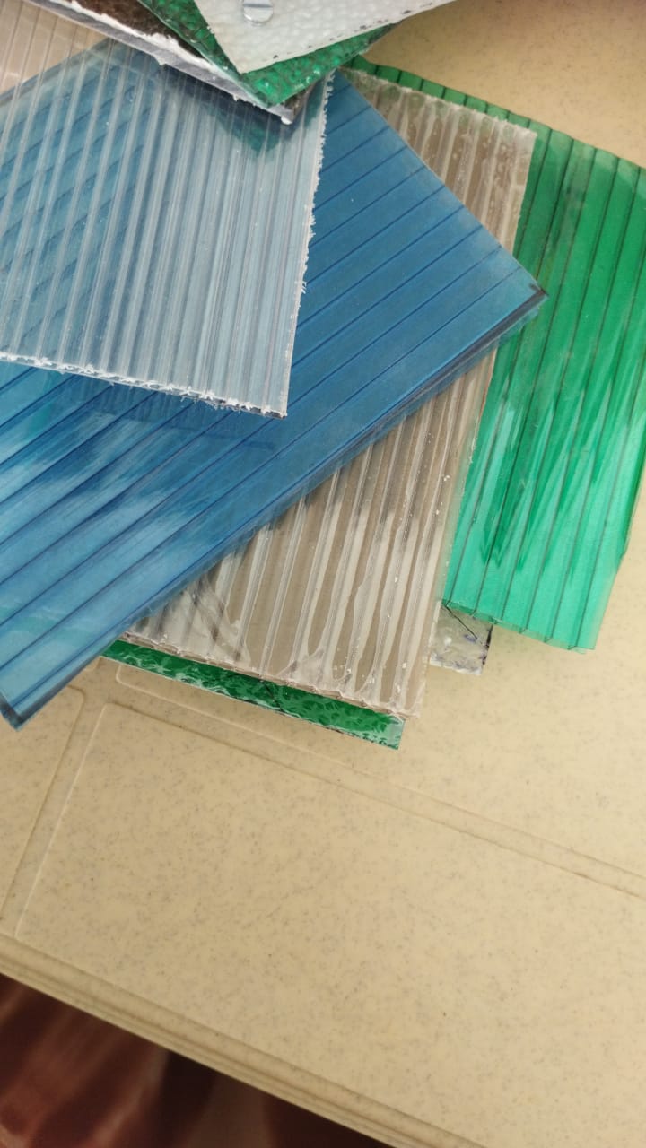Stacked multiwall polycarbonate samples in clear, blue, brown, and green.
